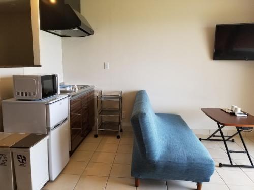 a kitchen with a blue chair and a table at terrace IRIOMOTEJIMA CONDOMINIUM in Iriomote