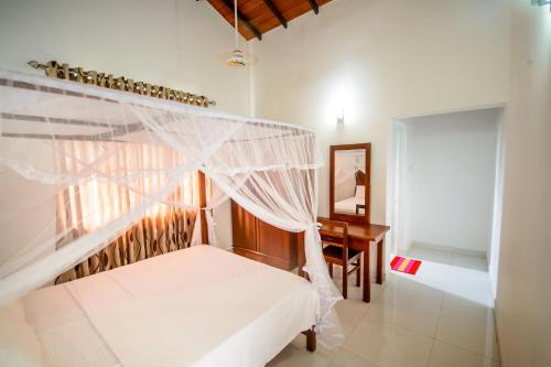 a bedroom with a bed with a mosquito net at NegomboVilla in Negombo