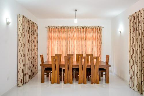 NegomboVilla في نيجومبو: غرفة طعام مع طاولة وكراسي خشبية