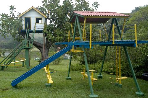 a playground with a blue slide and a house at Park Hotel Mantiqueira in Barbacena