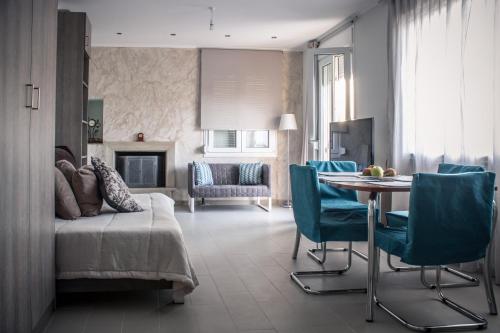 un soggiorno con divano, tavolo e sedie di Andromache Villas a Roumelí