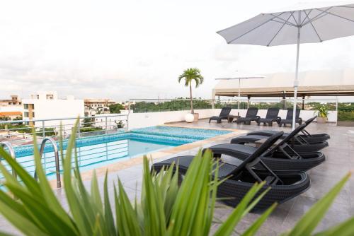 a swimming pool with lounge chairs and an umbrella at Soho Playa Hotel in Playa del Carmen