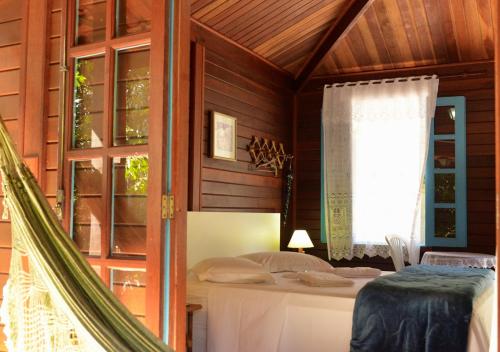 a bedroom with a bed and a window at Pousada Encontro dos Rios in Lumiar