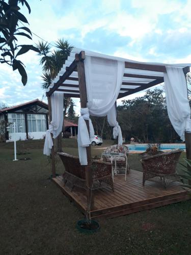a gazebo with a table and chairs on a deck at Pouso dos Querubins in Tiradentes