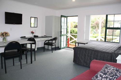 a hotel room with a bed and a table and chairs at Kerry Lane Motel in Hawera