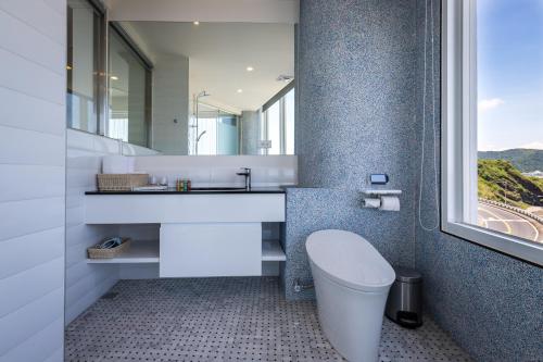 a bathroom with a sink and a toilet and a window at Brighthouse in Suao