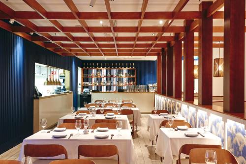 a dining room with white tables and chairs at The Ville Resort - Casino in Townsville