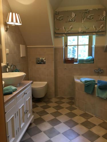 a bathroom with a sink and a tub and a toilet at Itha’s secret escape in Langschlag