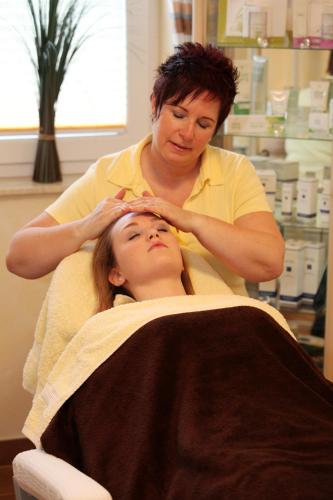a woman cutting a girls hair in a salon at Landhotel Teuteberg in Bad Arolsen