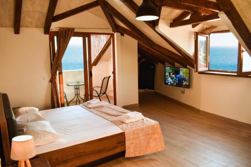 ein Schlafzimmer mit einem Bett in einem Zimmer mit Fenstern in der Unterkunft Villa Dulcinea in Ulcinj