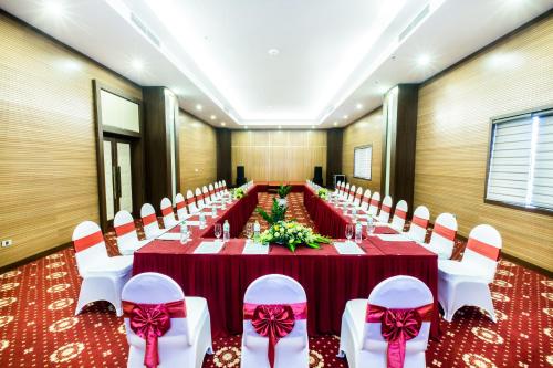 a long banquet hall with red tables and white chairs at Muong Thanh Grand Hoang Mai - Nghe An in Hoang Mai