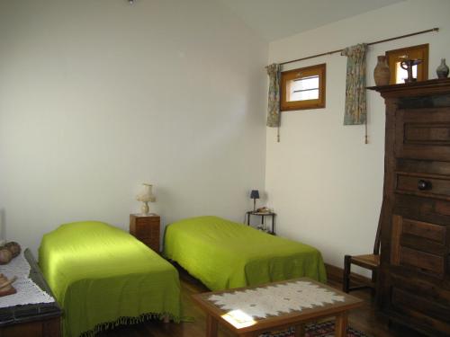 um quarto com duas camas verdes num quarto em Chambres d'hôtes Haut de Belleville em Paris