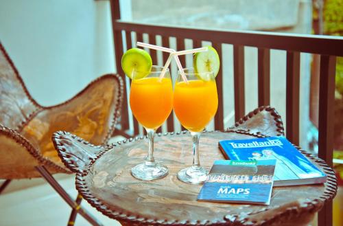 two glasses of orange juice on a table at Ayubowan Holiday Home in Kandy