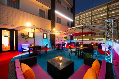 a restaurant with tables and chairs and umbrellas at Grand Park Hotel The Luxueux Minami Kashiwa in Kashiwa