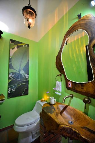 a bathroom with a toilet and a sink with a mirror at Finca Villa Gregory in Quimbaya