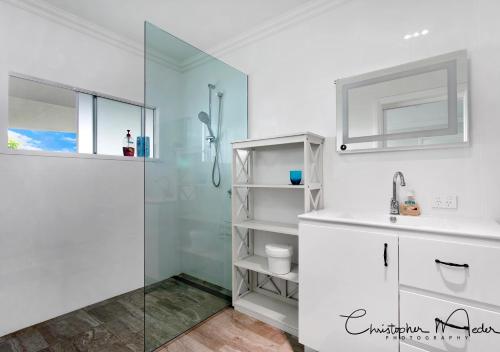 a bathroom with a shower and a sink at Jetty Beach Splendour Apartment in Coffs Harbour