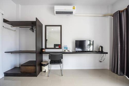 a room with a chair and a desk and a mirror at Mr.T Kamala Room in Kamala Beach