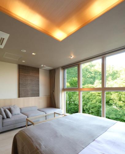 a bedroom with a large bed and a large window at Hotel Gendairakuen Isehara in Isehara