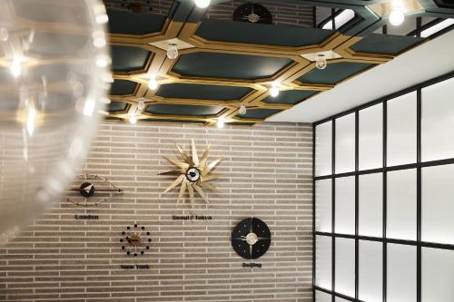 a ceiling with a clock on a brick wall at Hotel NewV in Seoul
