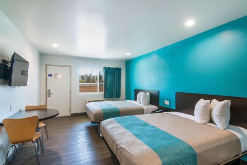 um quarto de hotel com duas camas e uma parede azul em Motel 6-South El Monte, CA - Los Angeles em South El Monte