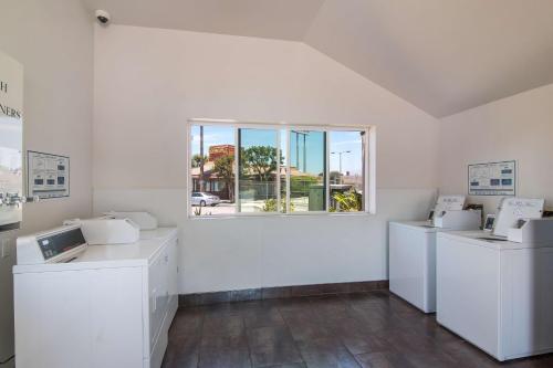 a white room with three washing machines and a window at Motel 6-South El Monte, CA - Los Angeles in South El Monte