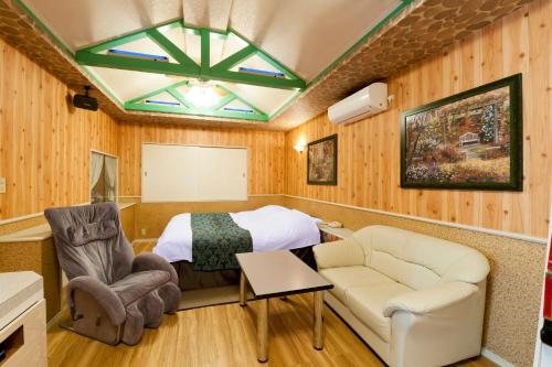 出雲市にあるホテル ファイン 出雲 エアポート（大人専用）のベッド、ソファ、椅子が備わる客室です。