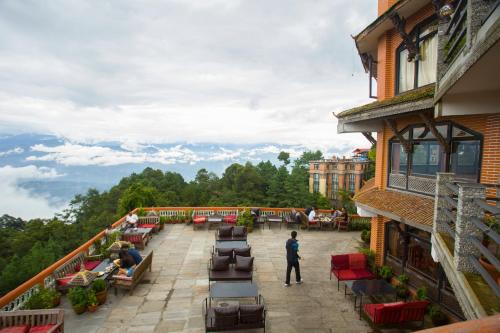 a man standing on the balcony of a building at Peaceful Cottage & Cafe Du Mont in Nagarkot