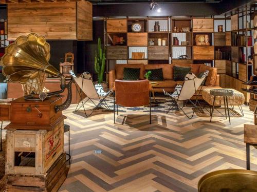 a room with a checkered floor with chairs and a couch at Novotel Avignon Nord in Sorgues