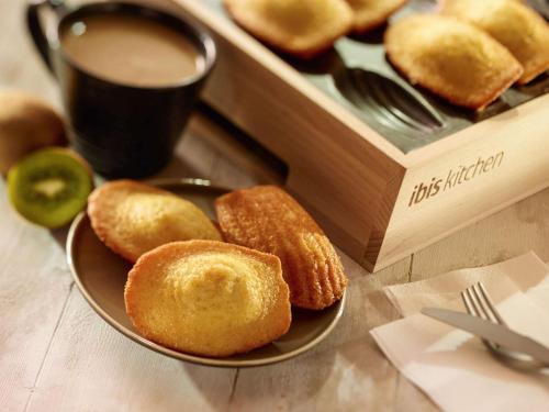 a plate of donuts on a table with a cup of coffee at ibis Paris La Villette Cité des Sciences 19ème in Paris