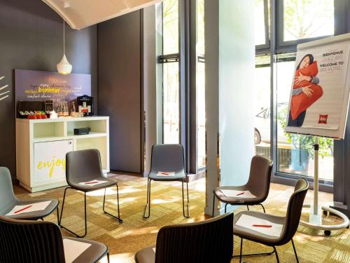 a waiting room with chairs and a poster on the wall at ibis Paris La Villette Cité des Sciences 19ème in Paris