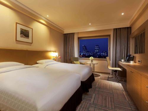 a hotel room with a large bed and a window at Novotel Ambassador Seoul Gangnam in Seoul