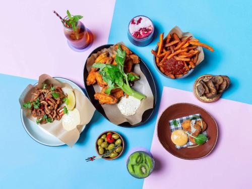 a table topped with plates of food and snacks at Novotel Sydney Olympic Park in Sydney