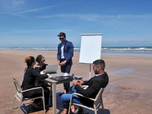 a group of people sitting at a table on the beach at Pullman Mazagan Royal Golf & Spa in El Jadida