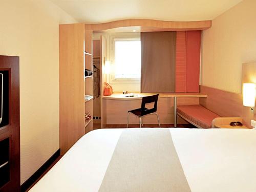 a hotel room with a bed and a desk at ibis Sint Niklaas Centrum in Sint-Niklaas