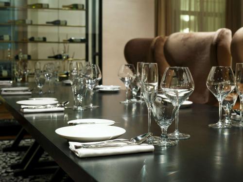 a table with wine glasses and plates on it at The Lake Garden Hotel Nay Pyi Taw - MGallery Collection in Nay Pyi Taw