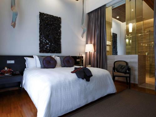 a bedroom with a large white bed and a desk at The Lake Garden Hotel Nay Pyi Taw - MGallery Collection in Nay Pyi Taw