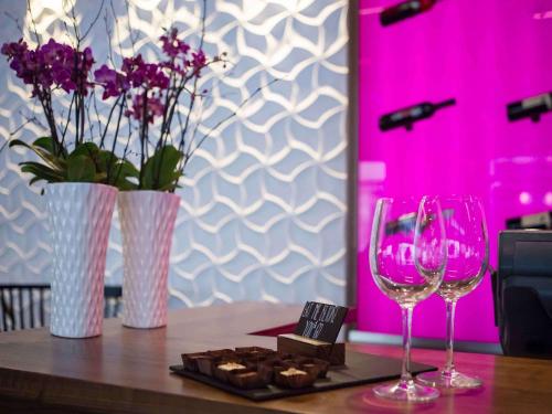 a table with two wine glasses and a plate of cookies at Mercure Krakow Stare Miasto in Kraków