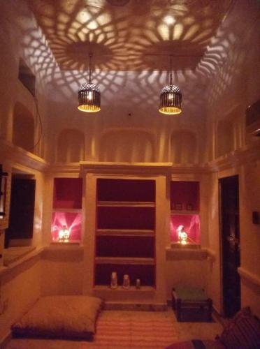 a living room with two chandeliers on the ceiling at Inn Seventh Heaven in Pushkar