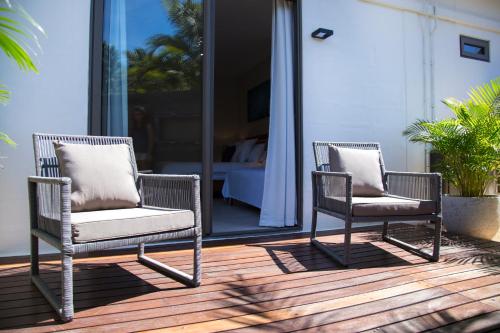 two wicker chairs sitting on a wooden deck at Les 2 canons in Flic-en-Flac