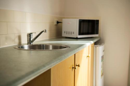 a kitchen counter with a sink and a microwave at Rose Garden Motel in Geelong