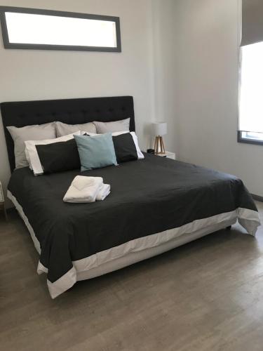 una camera da letto con un grande letto con una coperta nera di Wine Country Tourist Park Hunter Valley a Nulkaba