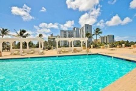 a large blue swimming pool in front of a city at Hawaiian Monarch Upgraded Modern Studio in Honolulu
