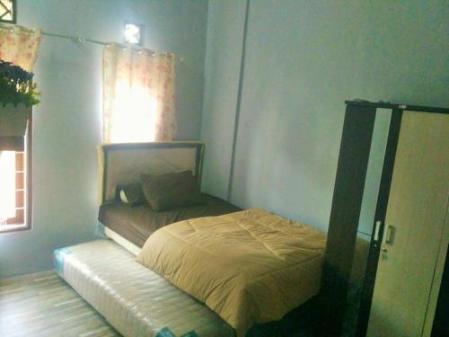 a small bedroom with a bed and a window at Homestay Bumi Asri III Cikutra in Bandung