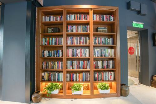a book shelf filled with books and potted plants at The Bed KLCC in Kuala Lumpur