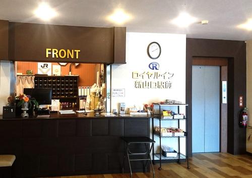 a store with a front counter with a clock on the wall at Royal Inn Shinyamaguchi Ekimae in Yamaguchi