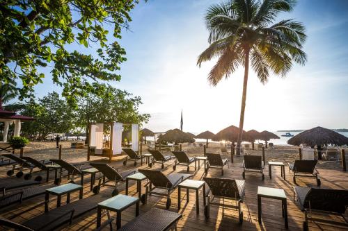 a beach area with tables, chairs and umbrellas at BlueBay Villas Doradas Adults Only-All Inclusive in San Felipe de Puerto Plata