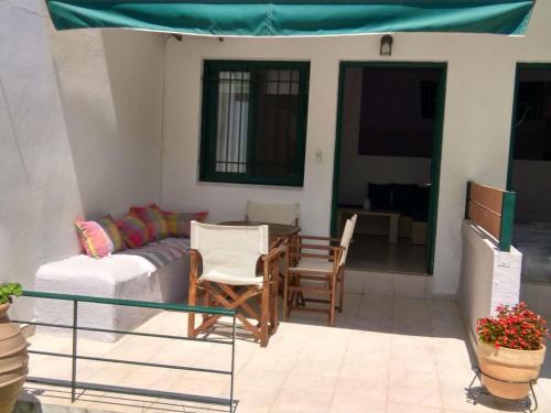 a living room with a couch and a table and chairs at Elina Apartments in Parga