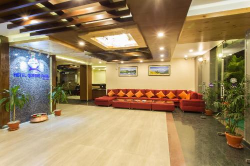 a lobby with red couches and potted plants at Hotel Queens Park in Pokhara