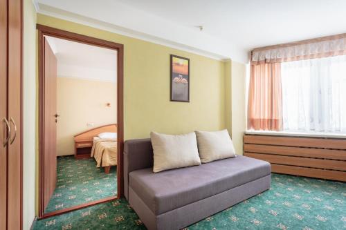 a room with a couch in front of a mirror at Tourist Hotel Complex in Kyiv