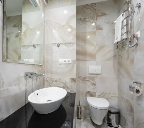 a white bathroom with a sink and a toilet at Tourist Hotel Complex in Kyiv